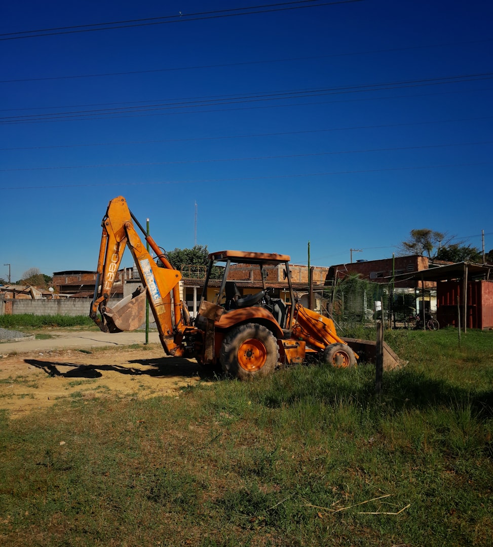 A tractor is parked in a field with a building in the background
